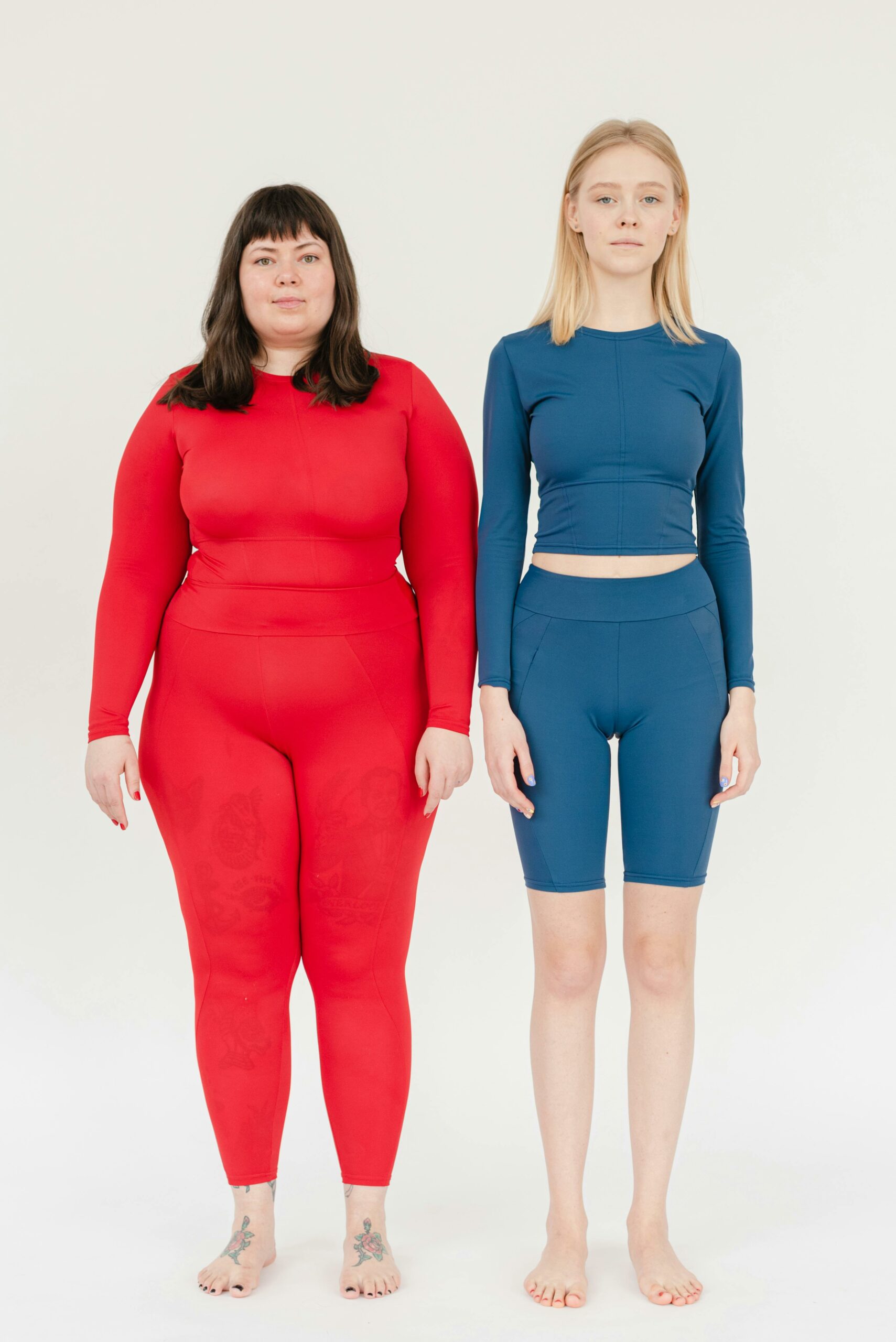 Two women in colorful sportswear posing confidently against a white background.